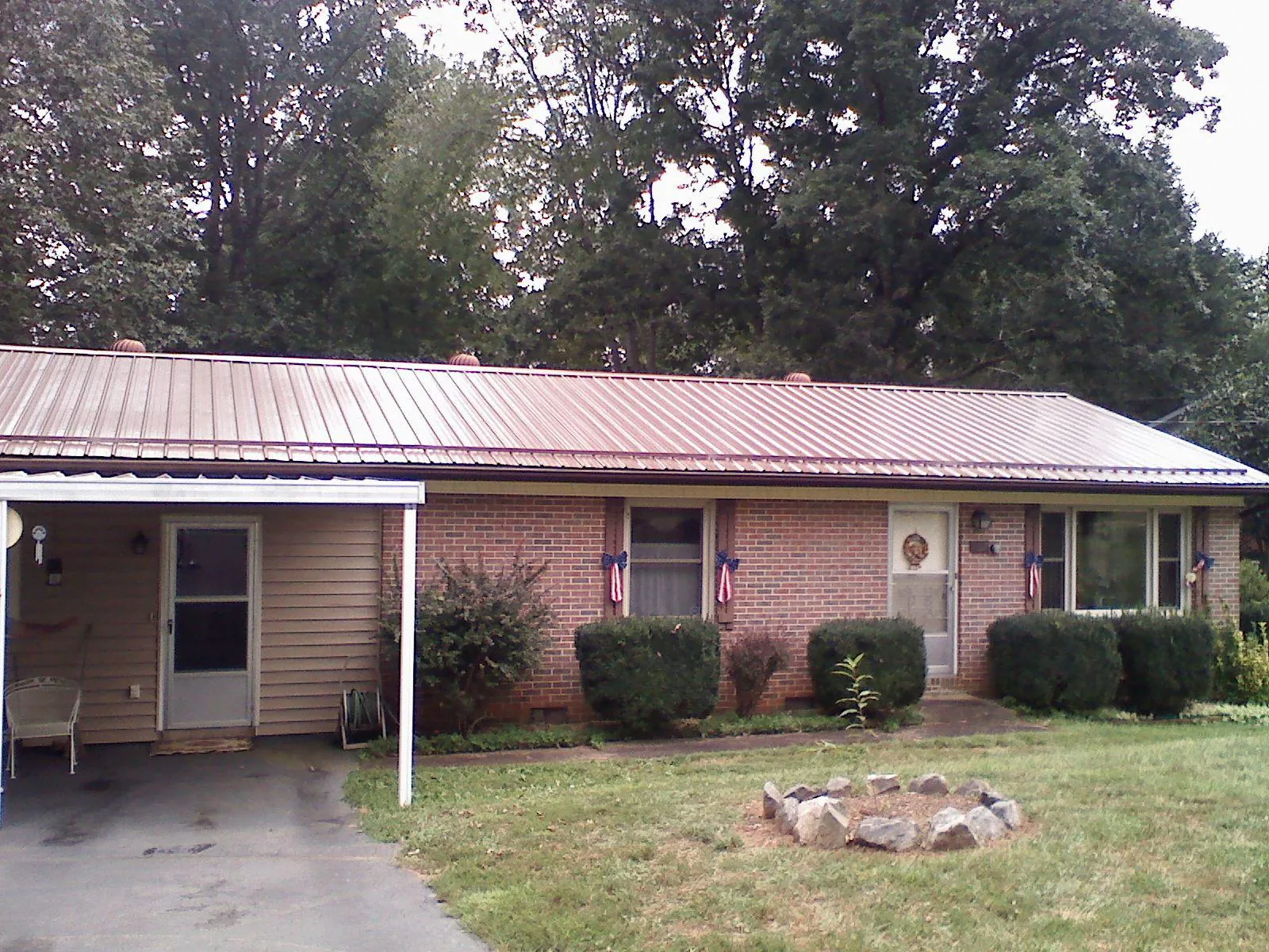 Bronze metal roof and carport on a brick ranch home — Roof Repair work by our crew in Belgium