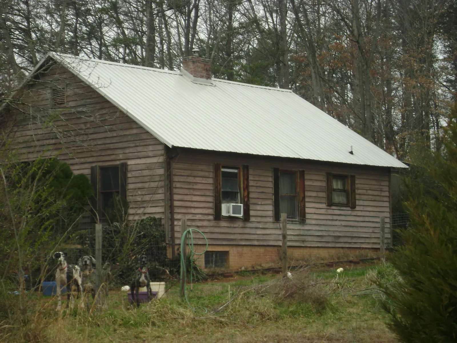 White metal roof on an old wood sided farmhouse, from a Metal Roof Installation job in Belgium
